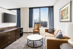 a living room with a couch and a tv at Fairfield Inn & Suites by Marriott New York Midtown Manhattan/Penn Station in New York