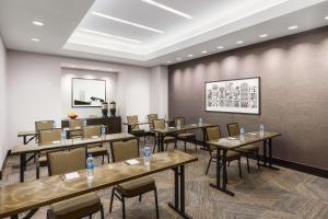 una sala da pranzo con tavoli, sedie e un muro di Fairfield Inn & Suites by Marriott New York Midtown Manhattan/Penn Station a New York