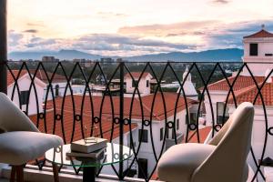 einen Balkon mit Stühlen und Stadtblick in der Unterkunft AC Hotels by Marriott Guatemala City in Guatemala