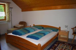 Un dormitorio con una cama con almohadas azules. en Ferienwohnung en Fraxern