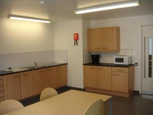 a kitchen with wooden cabinets and a table and a microwave at Goldsmid House, Victoria in London