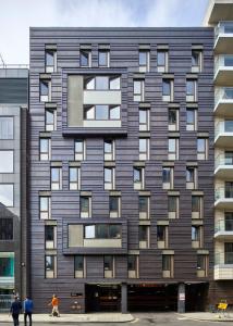 Un grand bâtiment avec des gens qui marchent devant lui dans l'établissement Goldsmid House, Victoria, à Londres