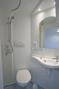 a white bathroom with a toilet and a sink at Goldsmid House, Victoria in London