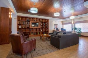 een woonkamer met een bank en stoelen en een tv bij Four Points by Sheraton Saskatoon in Saskatoon