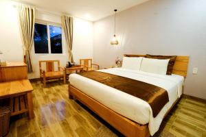 BB Hotel&Resort في فو كووك: غرفة نوم بسرير ومكتب ونافذة