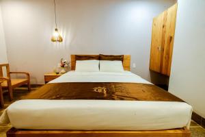 a bedroom with a large bed with a wooden headboard at BB Hotel&Resort in Phu Quoc