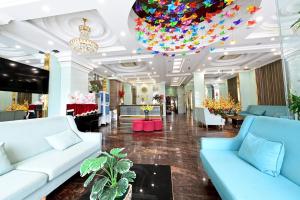 a lobby with blue couches and a chandelier at Adina 3 Star Hotel in Danang