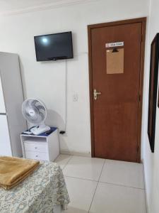 una stanza con una porta marrone e un ventilatore di Cantinho do Canaã ad Arraial do Cabo