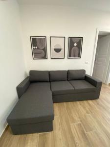 czarna kanapa w salonie z obrazami na ścianie w obiekcie Le Pavoncelle w mieście Valledoria