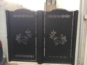 um par de portas pretas com galinhas pintadas nelas em Le Pavoncelle em Valledoria