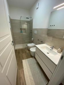 een badkamer met een wastafel, een toilet en een spiegel bij Le Pavoncelle in Valledoria