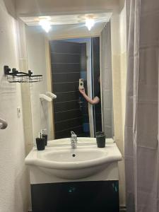 una persona que toma una foto de un lavabo en un baño en Lourdes Home en Lourdes