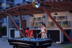 a man and a woman playing pool in a pool table at Fairfield by Marriott Bali Kuta Sunset Road in Kuta