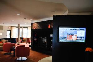 a living room with a flat screen tv on a wall at Courtyard Salina in Salina