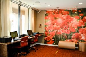 ein Büro mit zwei Schreibtischen mit Computern und einem Blumenbild in der Unterkunft Courtyard Salina in Salina