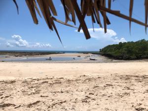 a beach with a person in the water at Porini House in Dar es Salaam