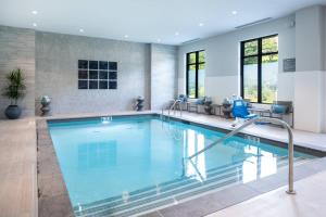 a large swimming pool with blue water in a building at Residence Inn by Marriott Boston Waltham in Waltham