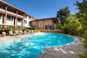 a swimming pool with chairs and a building at Sheraton Redding Hotel at the Sundial Bridge in Redding