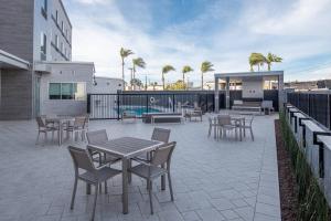 a patio with tables and chairs next to a building at Fairfield by Marriott Inn & Suites Anaheim Los Alamitos in Los Alamitos
