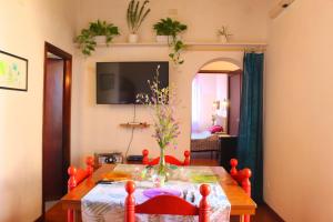 a dining room with a table with red chairs at La terrazza sugli aranci in Rio Marina