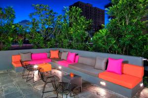 eine Couch mit bunten Kissen auf einer Terrasse in der Unterkunft Aloft Miami Brickell in Miami