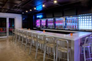 a bar with a row of bar stools in a room at Aloft Miami Brickell in Miami