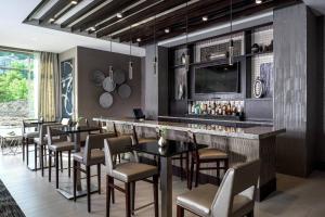 a restaurant with a bar with tables and chairs at Courtyard by Marriott Edgewater NYC Area in Edgewater
