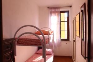 1 dormitorio con 2 literas y ventana en La terrazza sugli aranci en Rio Marina
