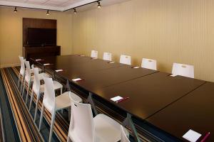 einen Konferenzraum mit einem langen Tisch und weißen Stühlen in der Unterkunft Aloft Miami Brickell in Miami