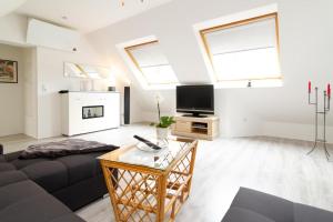 a living room with a couch and a tv at Ferienwohnung zwischen den Wieken in Ostrhauderfehn