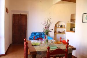 a dining room table with a vase of flowers on it at La terrazza sugli aranci in Rio Marina