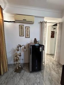 um quarto com um frigorífico no canto de um quarto em Cozy Nest - Garden Facing Apartment with Kitchen em Chandīgarh