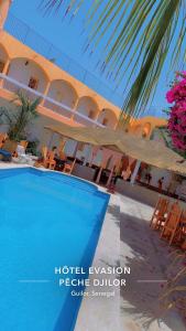 a hotel with a swimming pool in front of a building at Hôtel évasion pêche djilor île sine saloum in Fatick