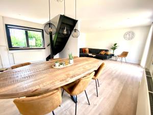 een woonkamer met een grote houten tafel en stoelen bij The island life beach house 2 in De Koog