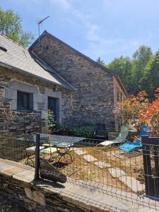 a stone house with a table and chairs in a yard at Gite rustique en Centre Bretagne in Laniscat