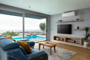 a living room with a blue couch and a tv at King´s View (Heated Pool and Sea View) in Estreito da Calheta