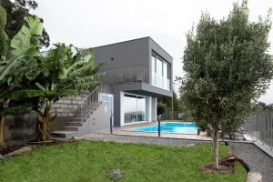 a house with a swimming pool in front of it at King´s View (Heated Pool and Sea View) in Estreito da Calheta
