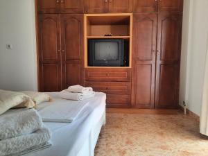 a bedroom with a tv and a bed with towels at Maria's Village Home in Glinado Naxos