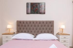 una camera con un letto con due comodini e due lampade di Renos House by Corfu Escapes a Vragkaniótika
