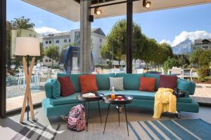 a blue couch on a patio with a table at Moxy Sion in Sion