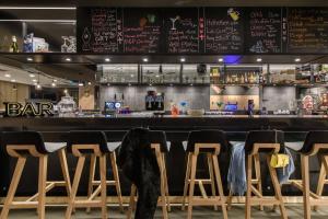 a person sitting at a bar with stools at Moxy Sion in Sion