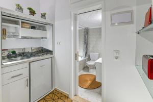 uma pequena cozinha branca com um lavatório e um WC em Hope apt - 5min to Falassarna Bch em Kissamos