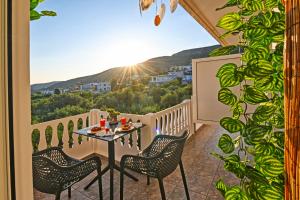 een tafel en stoelen op een balkon met uitzicht bij Hope apt - 5min to Falassarna Bch in Kissamos