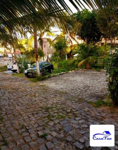 a stone walkway with a car parked in a greenhouse at Casa Tua Pipa in Pipa