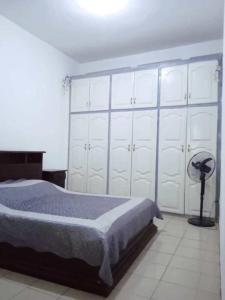 a bedroom with a bed and a large white closet at Cybhouse in Yaoundé