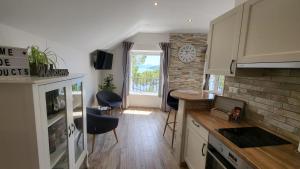 a kitchen with white cabinets and a brick wall at Old Town Sea Front M&M Apartment Korčula in Korčula