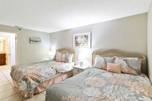 two beds sitting next to each other in a bedroom at 108 Beach Place Condos in St Pete Beach