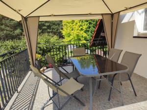 patio ze stołem i krzesłami na balkonie w obiekcie Berneński Zakątek w Charzykowach