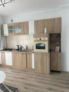 a kitchen with wooden cabinets and a stove top oven at West View by DAT Apartments in Cluj-Napoca