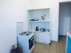 a kitchen with a stove and a refrigerator at Cybhouse in Yaoundé